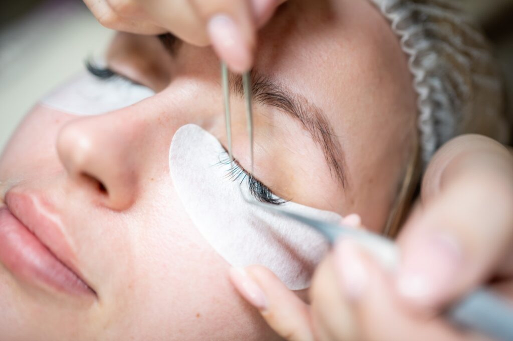 Eyelash extension procedure in beauty salon. Lashes close up. Concept spa lash.